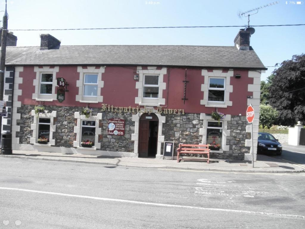 a red building on the corner of a street at Fitzpatrick's Tavern and Hotel in Cavan