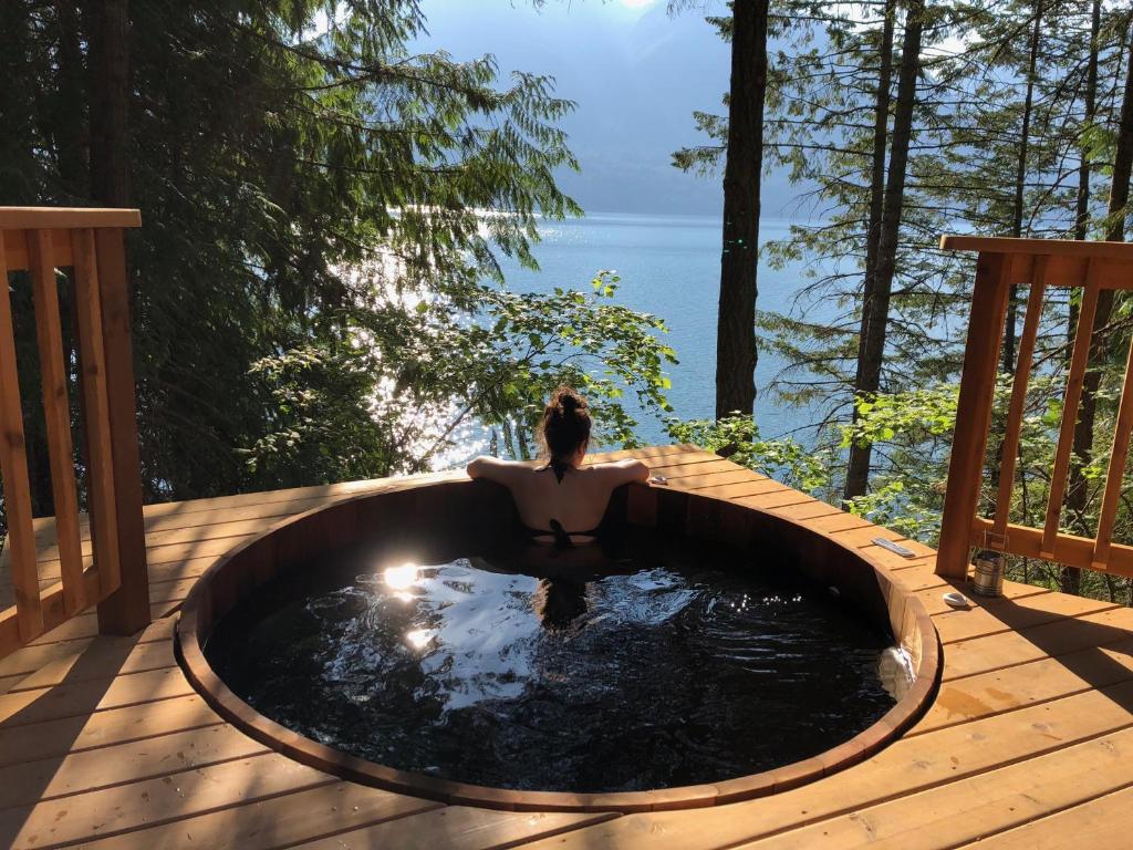 a woman sitting in a hot tub on a deck at The Sentinel in Kaslo