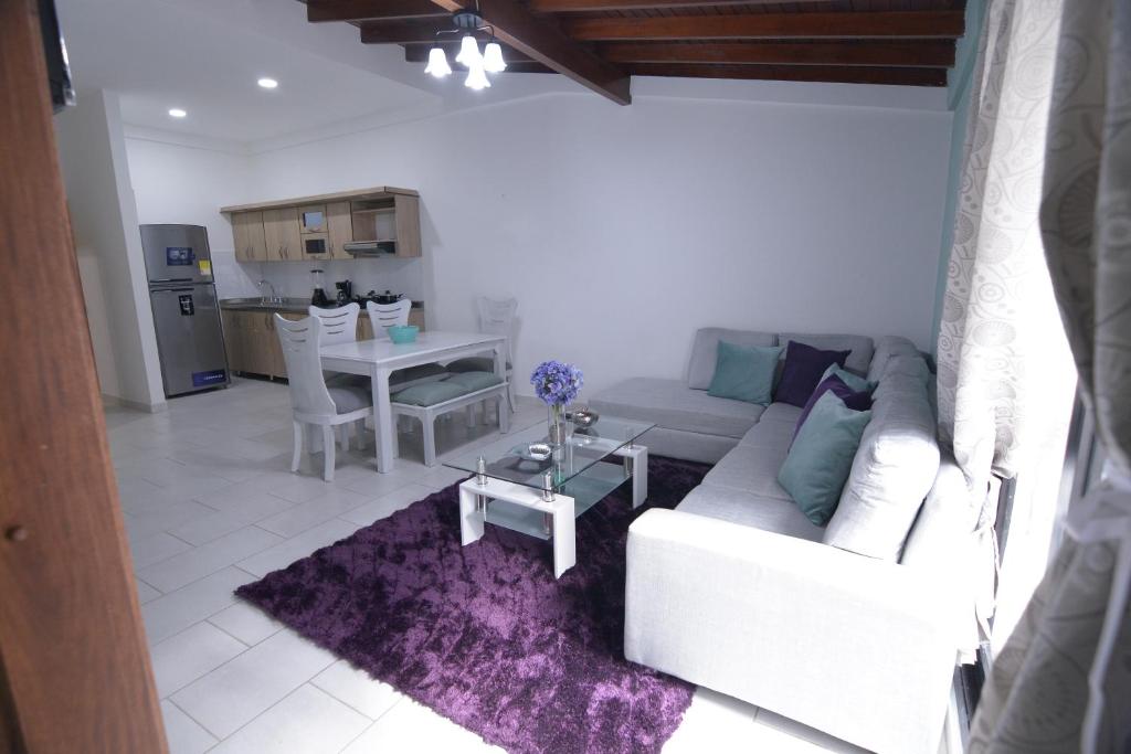 uma sala de estar com um sofá branco e uma mesa em apartamentos casa Margarita en laureles estadio su hogar en Medellin em Medellín