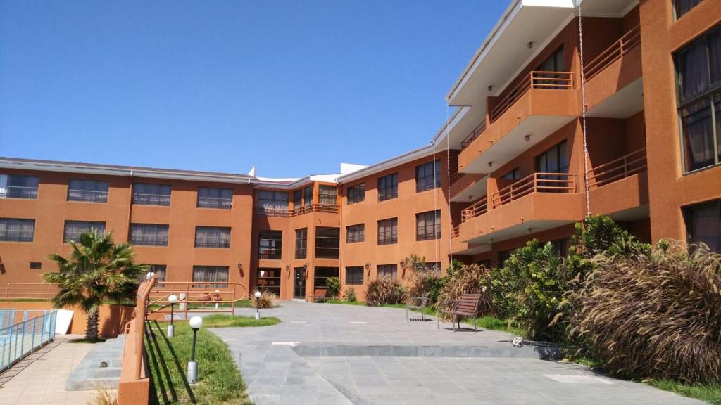 ein Apartmenthaus mit einem Gehweg davor in der Unterkunft Hotel Solaris in Huasco