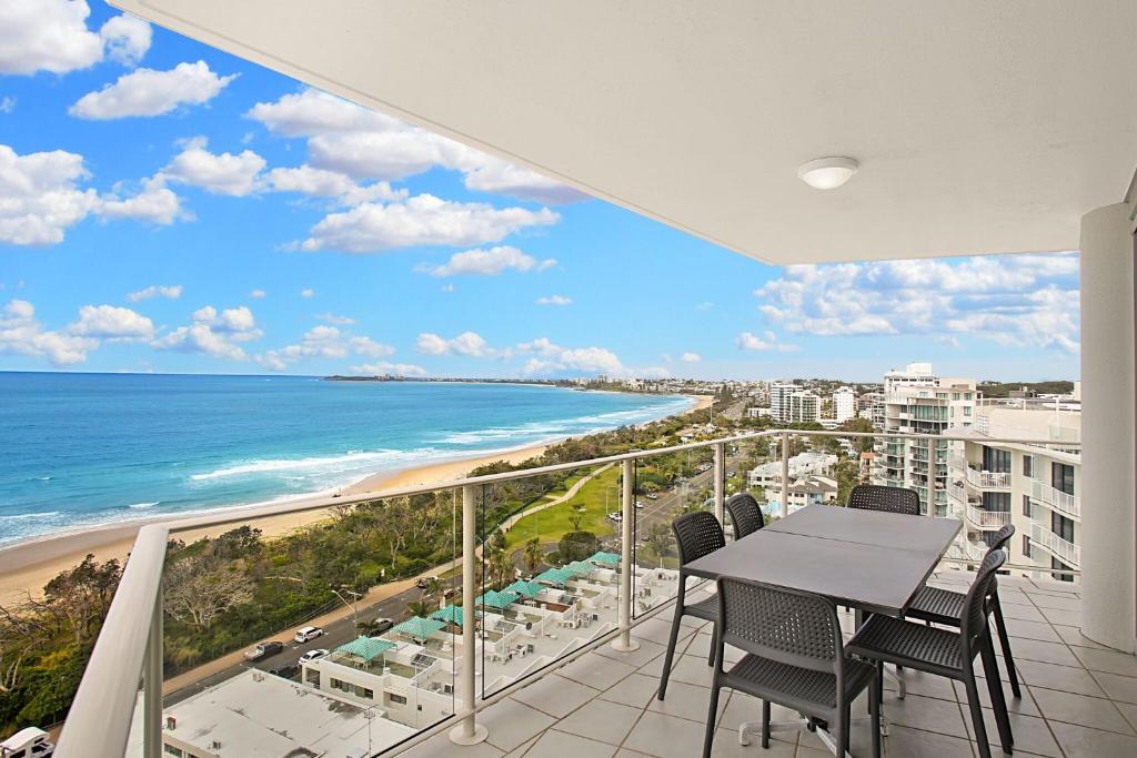 a balcony with a table and chairs and the ocean at Catalina Resort in Maroochydore