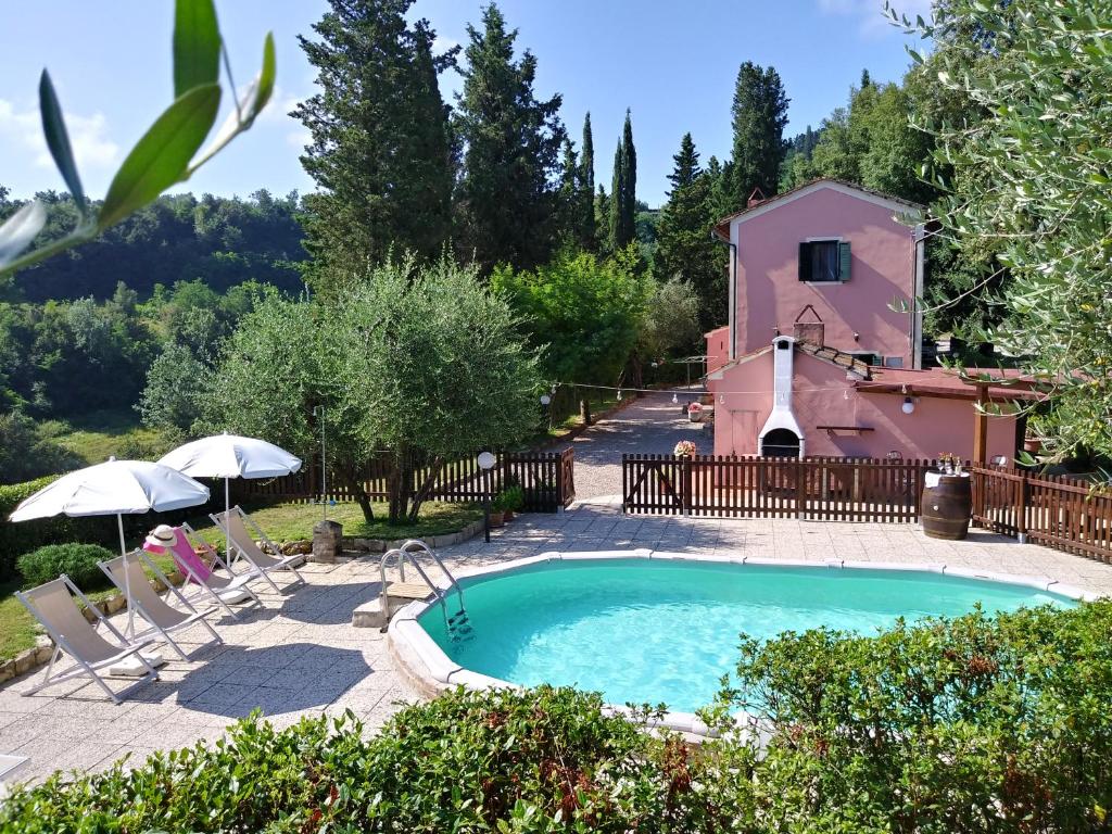 une piscine en face d'une maison avec un bâtiment dans l'établissement Podere Il Leccione, à Palaia