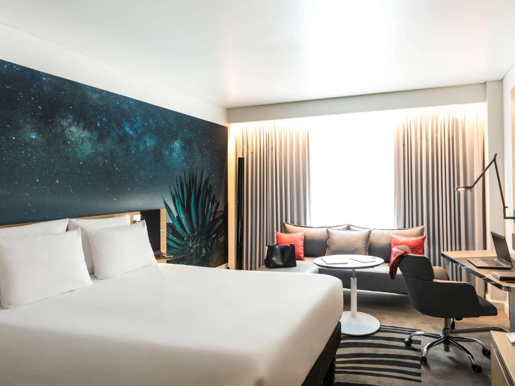een hotelkamer met een bed en een bank bij Novotel Mexico City Santa Fe in Mexico-Stad