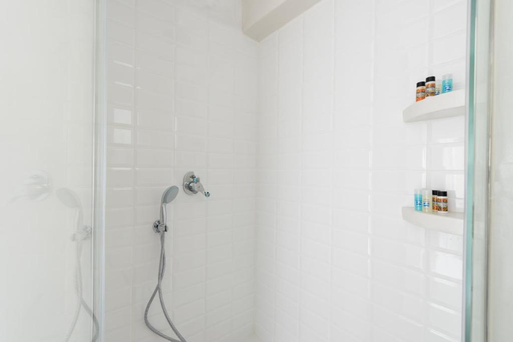 a shower with a shower head in a bathroom at Villa Renos Hotel in Fira