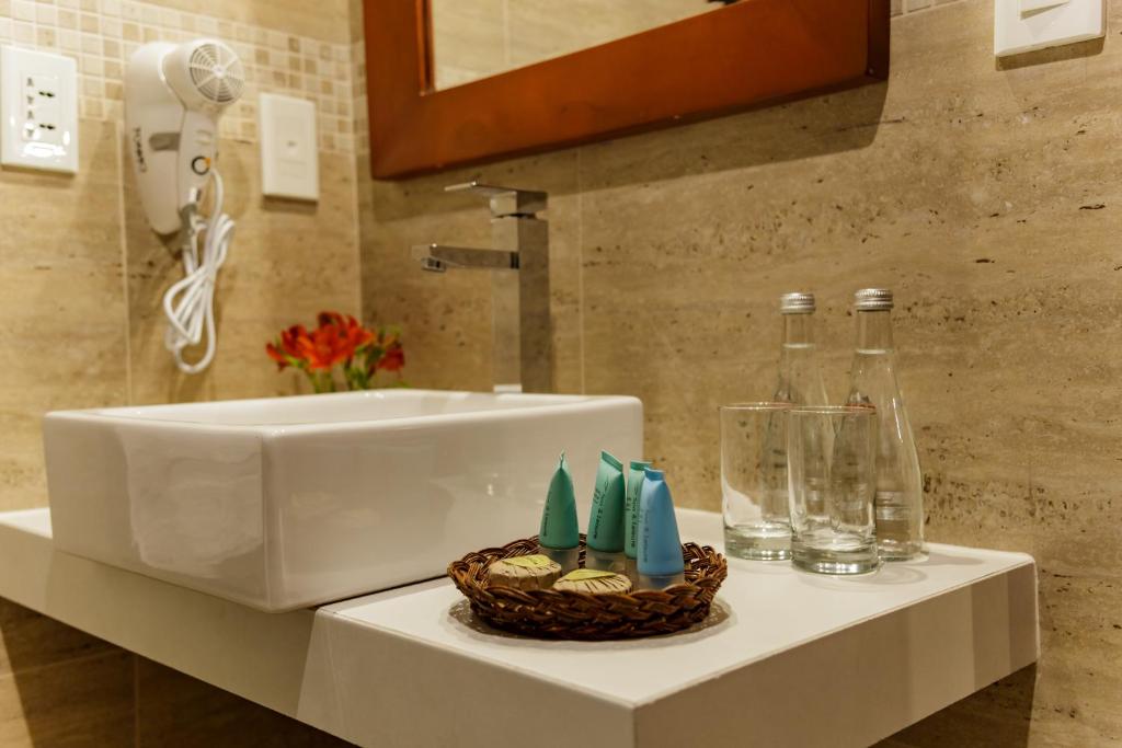 - Baño con lavabo y cesta de artículos de aseo en Yawar Inka Hotel, en Cusco