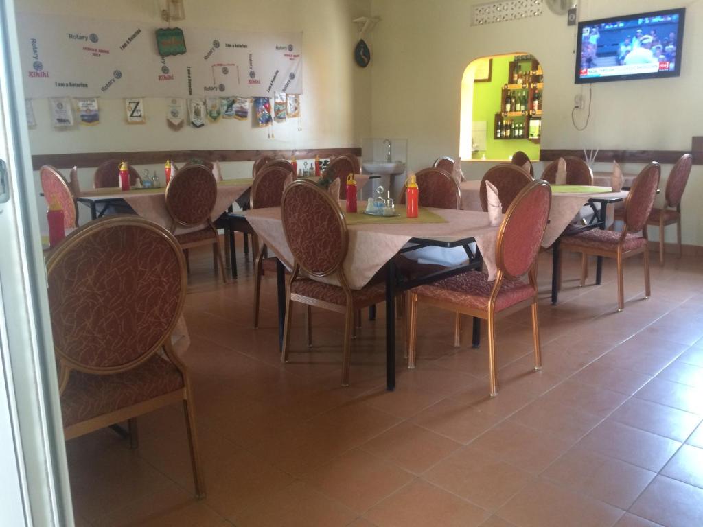 jadalnia ze stołami i krzesłami w restauracji w obiekcie Suba Motel w mieście Kihihi