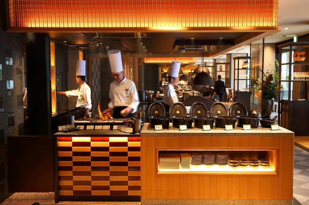 a group of chefs preparing food in a kitchen at Grand Prince Hotel Shin Takanawa in Tokyo