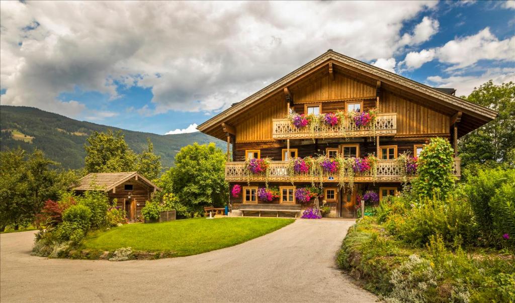 ein Haus mit einem Balkon mit Blumen darauf in der Unterkunft Hacklbauer in Altenmarkt im Pongau