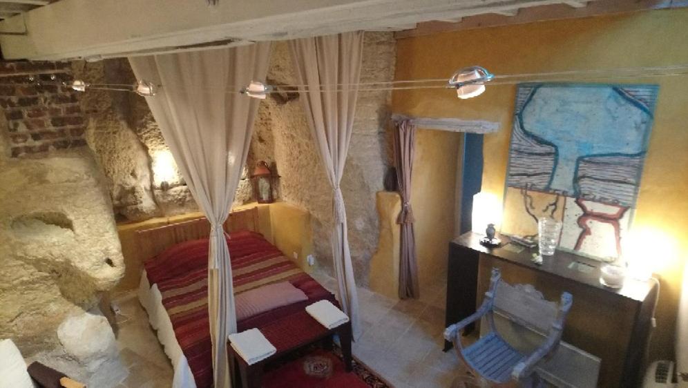 - une chambre avec un lit à baldaquin dans l'établissement Troglodyte loft, à Thoré-la-Rochette