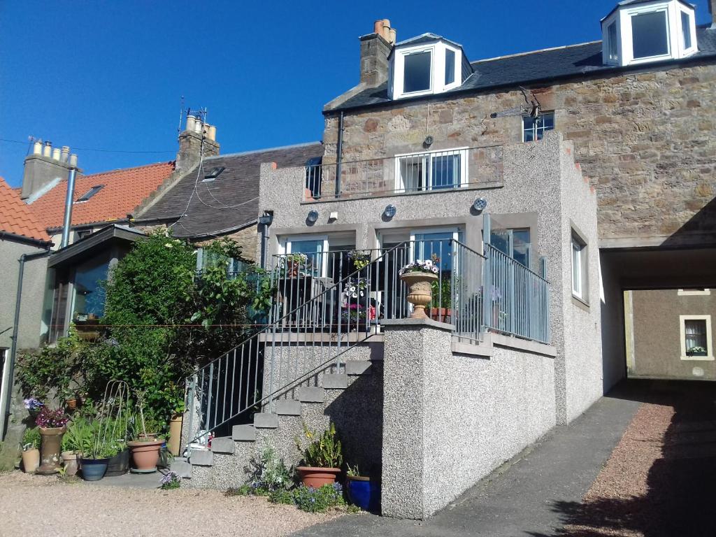 a stone house with a staircase in front of it at B&B at 37 in Anstruther