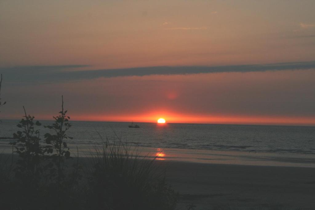 a sunset view of a beach with a sunset at Sint-Laureins in Westende