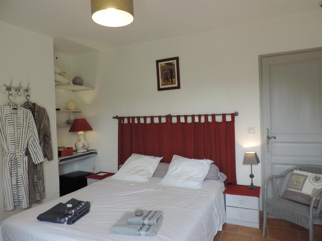 een slaapkamer met een bed met een rood hoofdeinde bij Le Faré Tchanqué Chambre d’hôtes Référence in Cavaillon