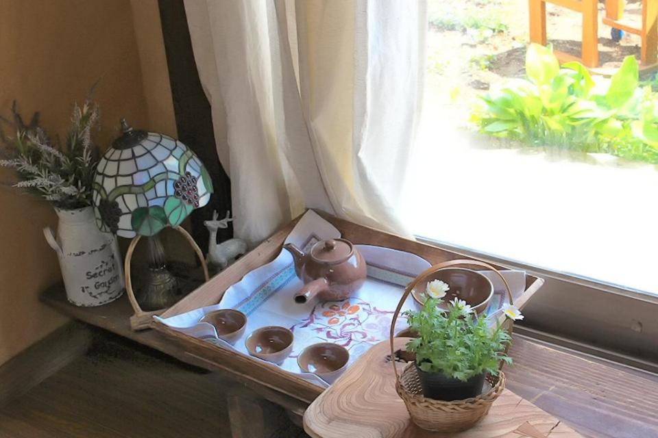 a table with a tea pot and plants in a window at Haengjin Guesthouse in Jeonju