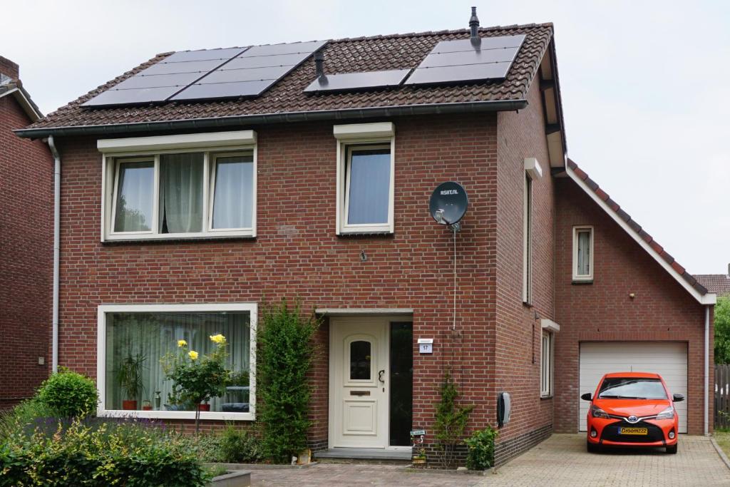 una casa de ladrillo rojo con paneles solares en el techo en Droomzzz en Herkenbosch