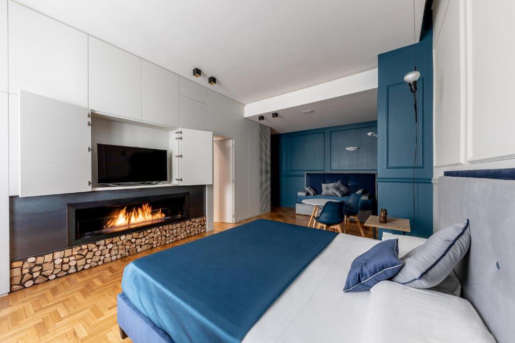 1 dormitorio con 1 cama y chimenea en Blue Inn Luxury Suites, en Roma