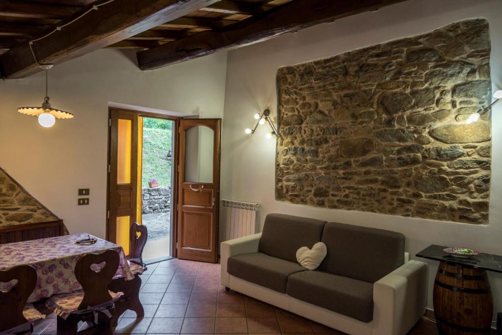 a living room with a couch and a stone wall at I 3 Porcellini in Cutigliano