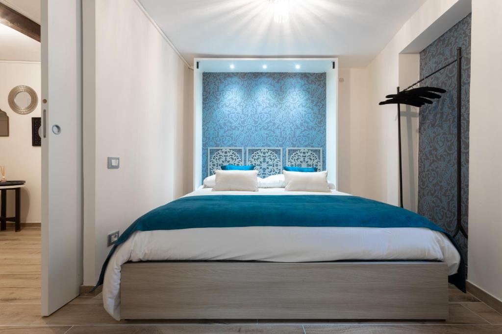 Schlafzimmer mit einem großen Bett mit blauem Kopfteil in der Unterkunft Venexia House to Rialto in Venedig