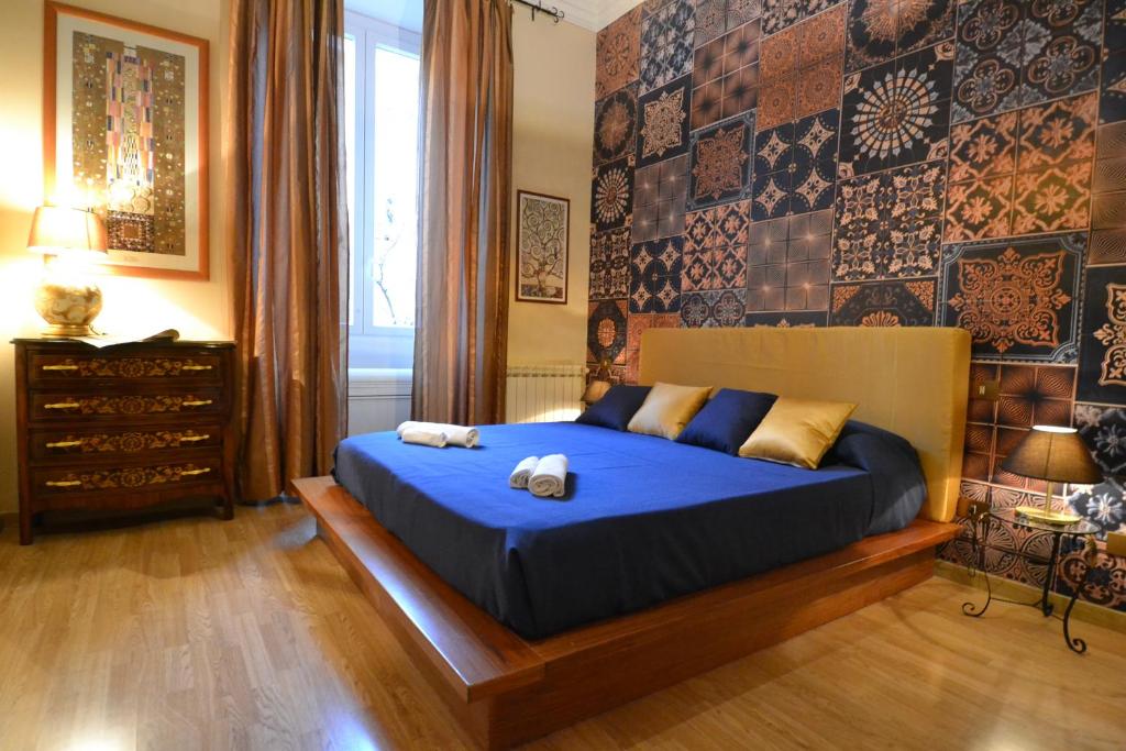 a bedroom with a blue bed and a wall with tiles at BDC - Maison Sophie al Vaticano in Rome