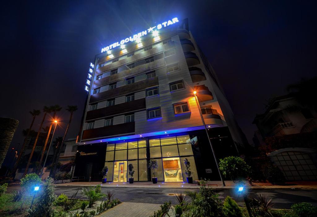 un edificio de hotel con luces azules por la noche en Golden Star Casablanca en Casablanca