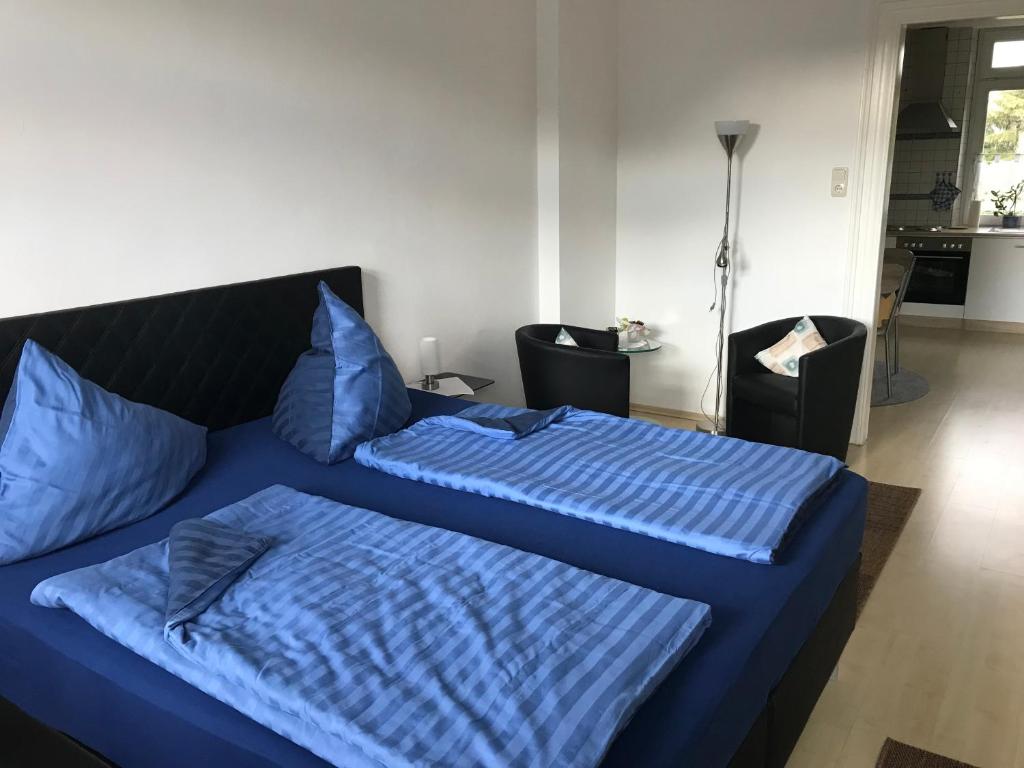 フェルバートにあるFerienwohnung Wienekeのベッドルーム1室(青いシーツが備わるベッド2台付)