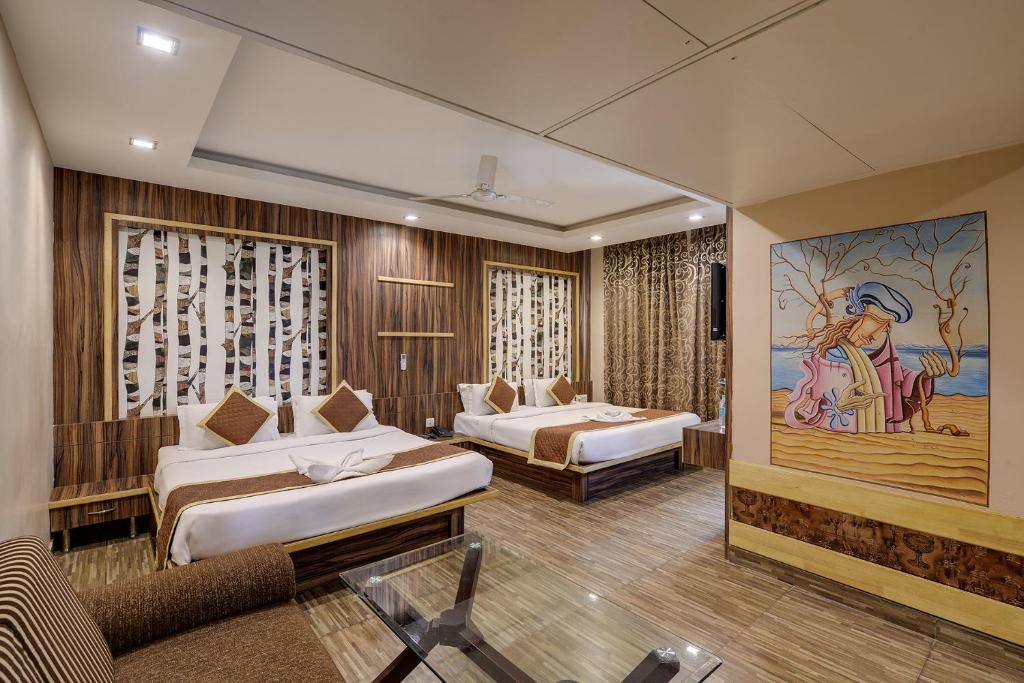 a hotel room with two beds and a painting on the wall at The Royal Melange Beacon in Ajmer