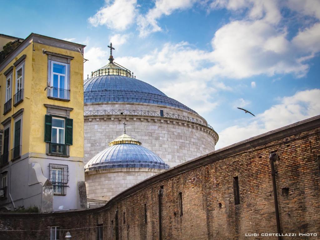 um edifício com cúpulas no topo de uma parede de tijolos em Spira Mirabilis Napoli em Nápoles
