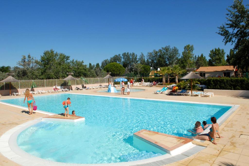 un grupo de personas sentadas en una piscina en Azureva Le Grau du Roi, en Le Grau-du-Roi
