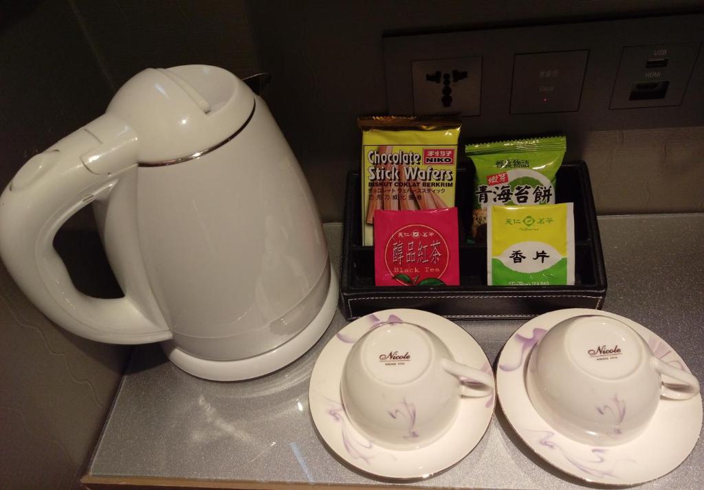 a white tea pot and two plates on a counter at Beauty Hotels Taipei - Hotel B7 in Taipei