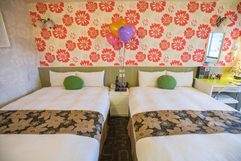 two beds in a room with a balloon and a balloonphasis at Ximen Relite Hotel in Taipei