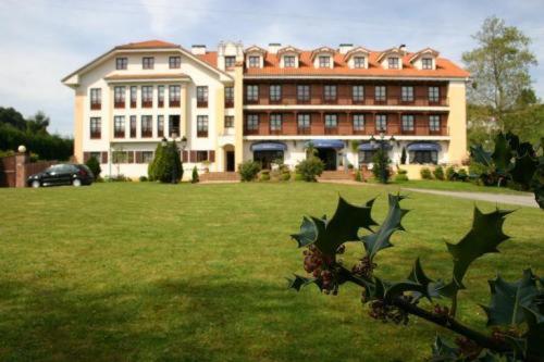 um grande edifício em frente a um grande campo de relva em Apartamentos Club Condal em Comillas