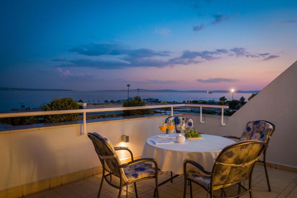 a table on a balcony with a view of the ocean at Seaside Apartment Gold 1row in Split