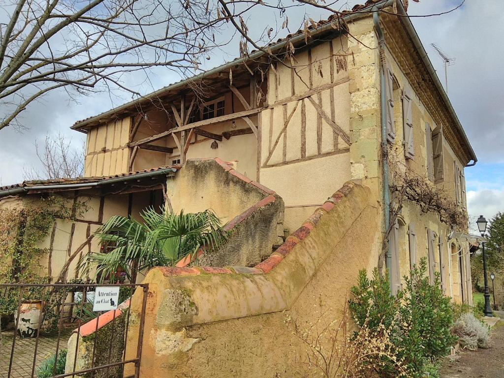 an old building with a fence in front of it at "Au campaner" chambres dans maison gasconne in Barran