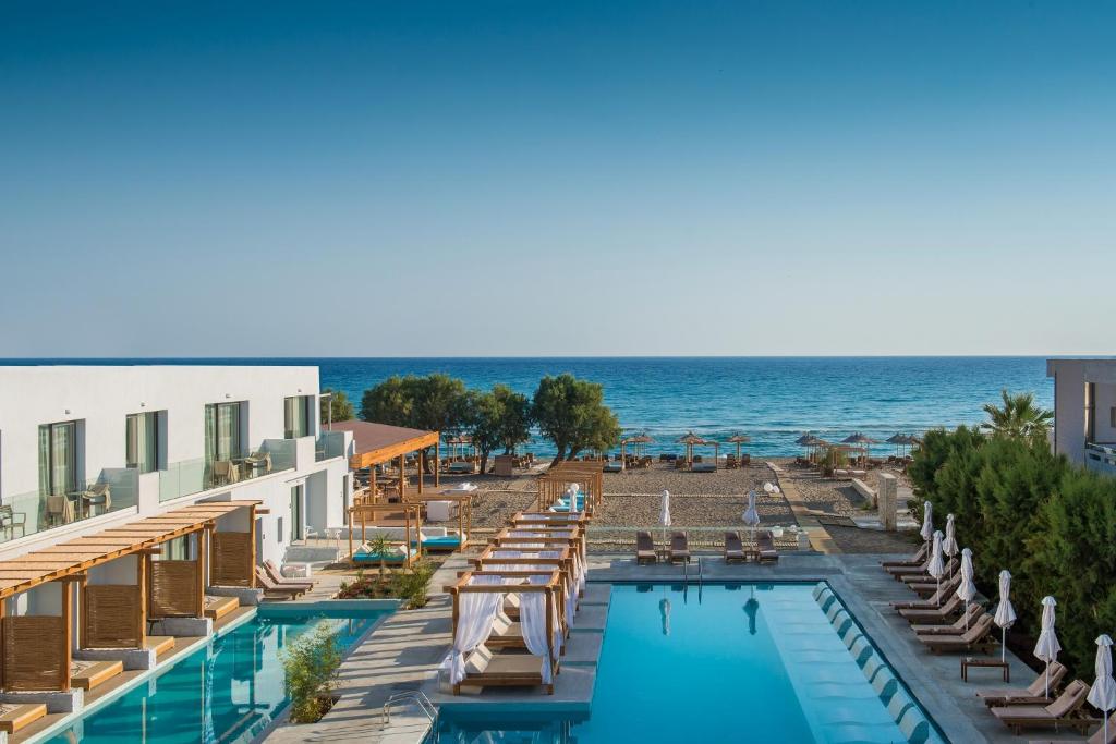 um hotel com piscina e oceano em Paralos Lifestyle Beach Adults Only em Amoudara Herakliou