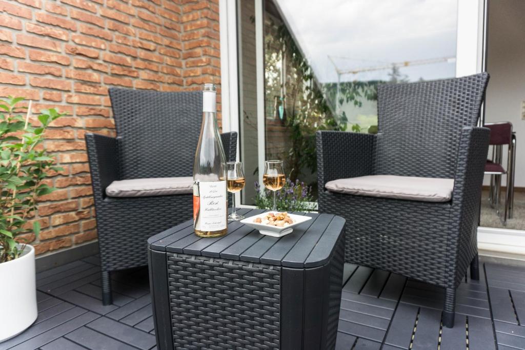 eine Flasche Wein auf einem Tisch auf einer Terrasse in der Unterkunft Moderne 70 qm Wohnung mit großer Dachterrasse in Kinheim
