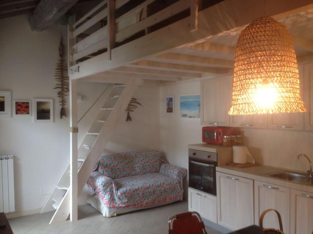 a living room with a loft bed and a chair at Casa Vacanze Carlappiano in Piombino