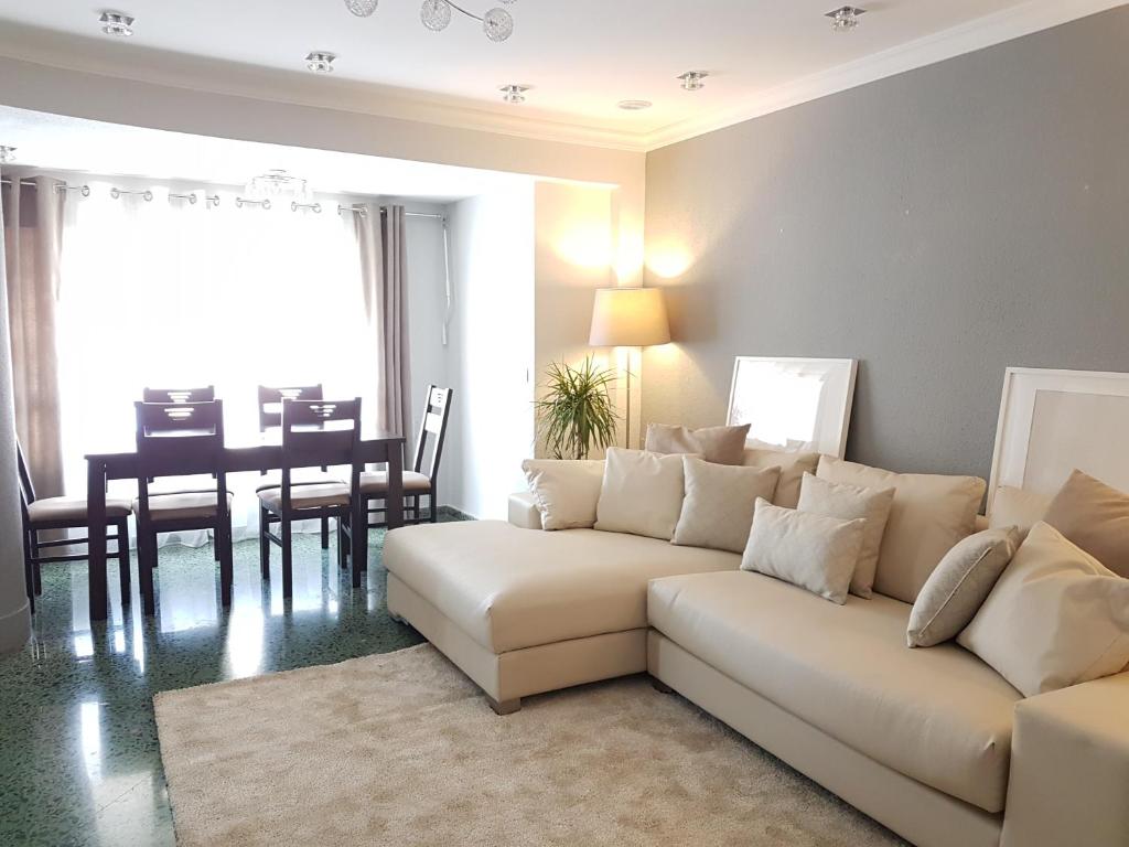 sala de estar con sofá blanco y comedor en MD Vila Barbera Apartment Center, en Valencia