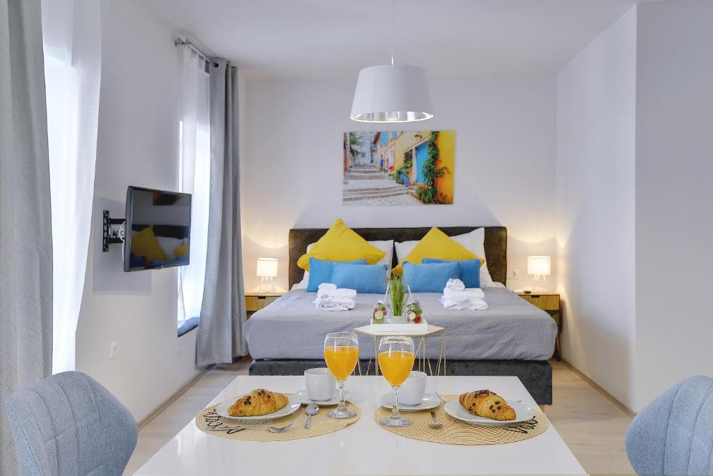 a bedroom with a bed and a table with plates of food at D&A Amphitheatre Apartments with free parking in Pula