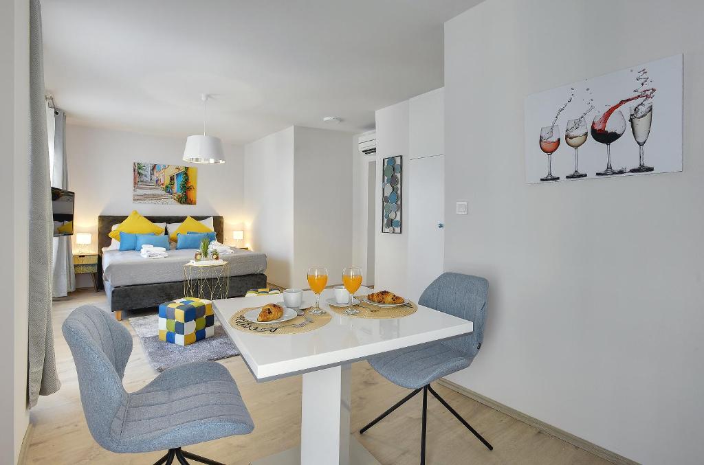 a living room with a table and chairs and a bed at D&A Amphitheatre Apartments with free parking in Pula