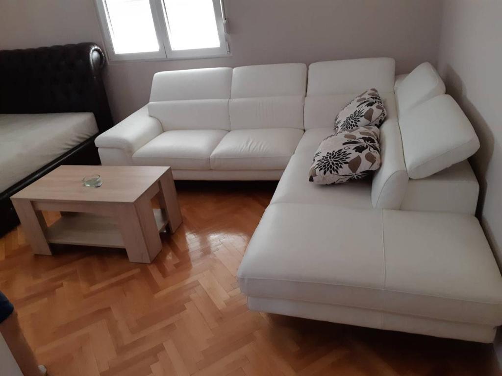 a living room with a white couch and a coffee table at Stankovic Apartman in Vranje