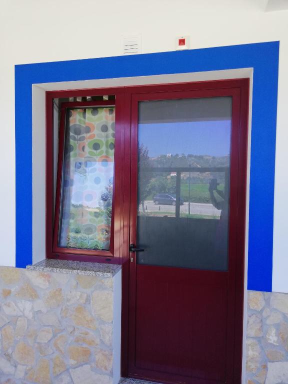 a red door with a window on a building at Sol Mar in Odeceixe
