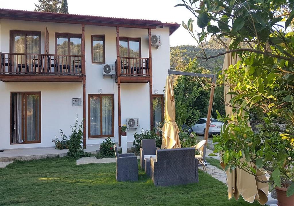 una casa con césped delante en Aydeniz Otel, en Mesudiye