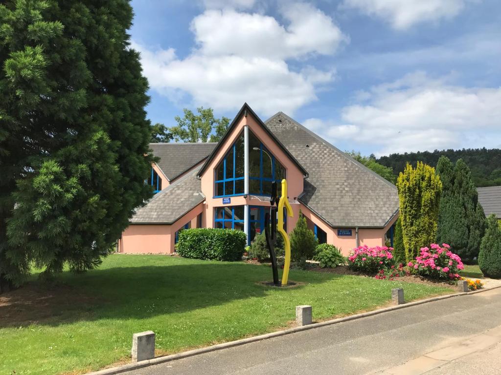 een roze huis met een grijs dak bij Résidence la Pyramide in Oberhaslach