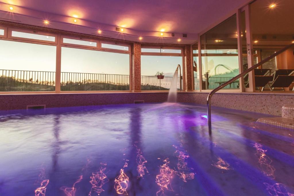 einen Pool mit violetten Lichtern in einem Haus in der Unterkunft Colleverde Country House & SPA Urbino in Urbino