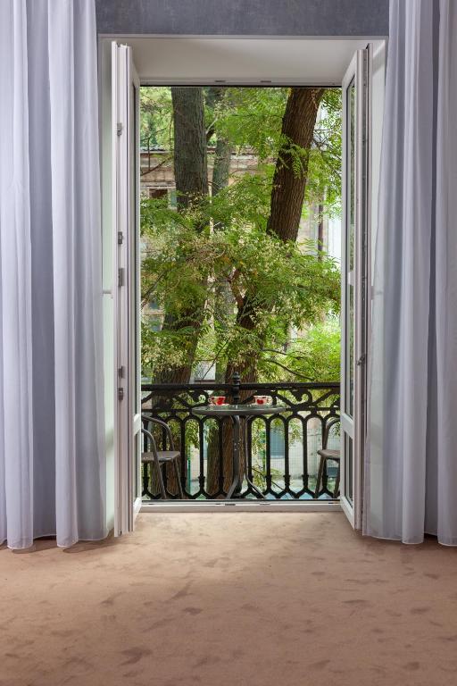 an open door to a patio with a table outside at Benefit Boutique Hotel in Odesa