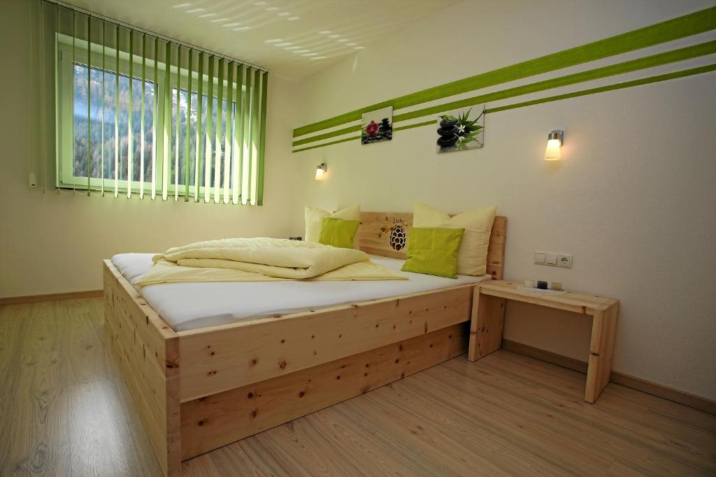 ein Schlafzimmer mit einem Holzbett und einem Fenster in der Unterkunft Apart Knabl in Sankt Leonhard im Pitztal