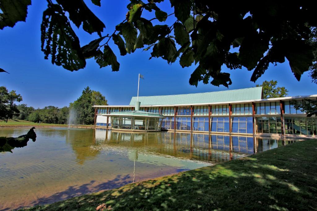 un gran edificio con agua delante en Logis des Lacs d'Halco, en Hagetmau