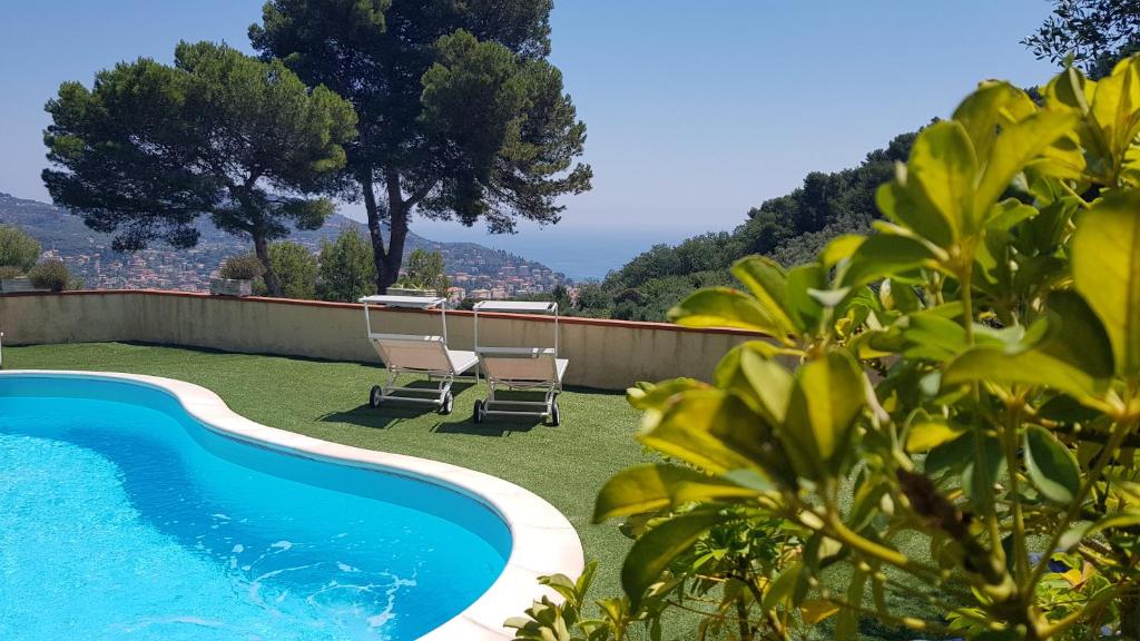 a swimming pool in a yard with two chairs and a table at Tenuta Domine in Imperia
