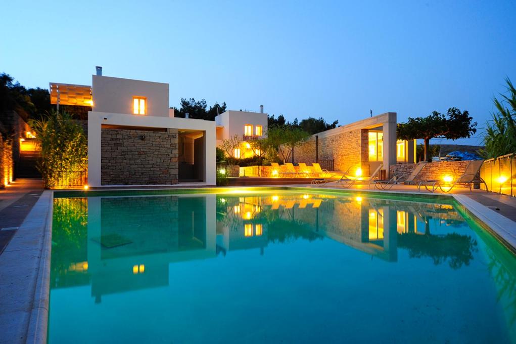 a swimming pool in front of a house at night at Petrokalli Houses in Kálamos Kythira