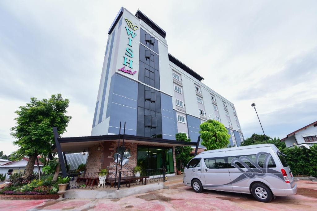 a small van parked in front of a building at Wish Hotel Ubon in Ubon Ratchathani