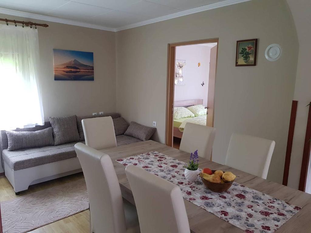 a dining room with a table and a couch at Apartman Anna in Ogulin